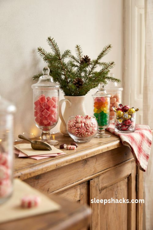 Colorful christmas candy display with glass jars filled with gumdrops peppermints and jelly beans