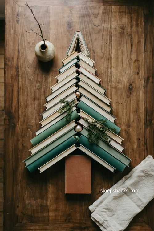 Diagonal herringbone book christmas tree with layered green books on dark wood 