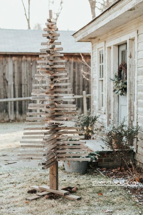 Dry brushed whitewashed pallet christmas tree with warm lights in a rustic farmhouse yard 