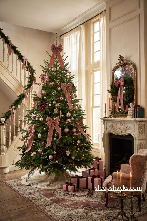 Dusty rose velvet ribbon and burgundy bows on a victorian christmas tree with antique gold ornaments