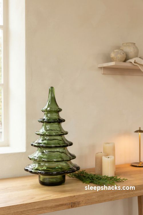 Emerald green glass christmas tree with white candles and natural wood decor