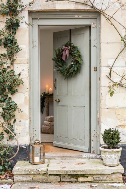 English country christmas front door wreath with pine greenery and vintage lantern 