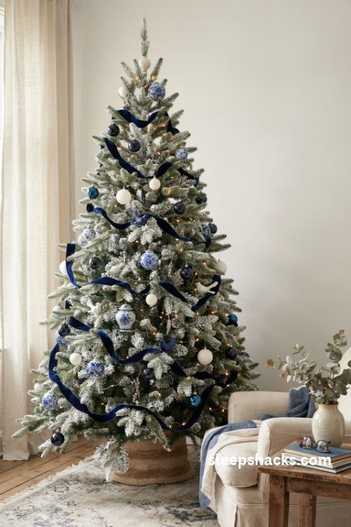 Flocked chinoiserie Christmas tree with cascading navy velvet ribbon and blue and white ornaments