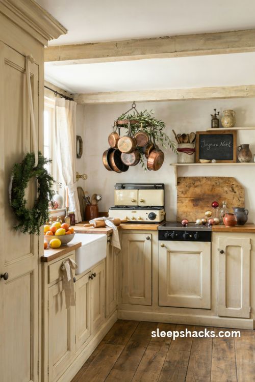 French country Christmas kitchen decor with copper pots evergreen garland linen bows vintage breadboards and a bowl of fresh clementines