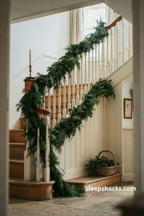 Full evergreen garland wrapped around a Christmas staircase banister with lush natural greenery