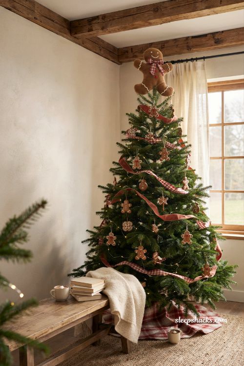 Giant gingerbread man tree topper with a red plaid bow on a christmas tree in a rustic living room