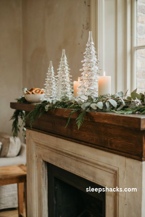 Glass christmas trees in graduated heights on a dark wood mantel