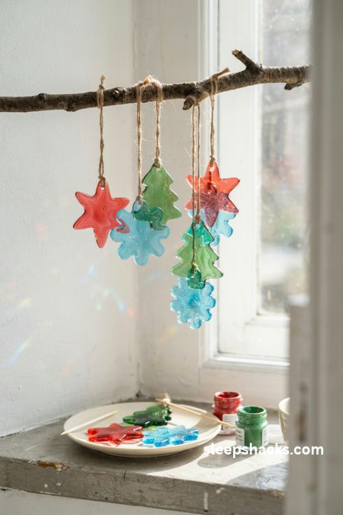 Glue peel Christmas suncatchers in red green and blue hanging in a sunny cottage window
