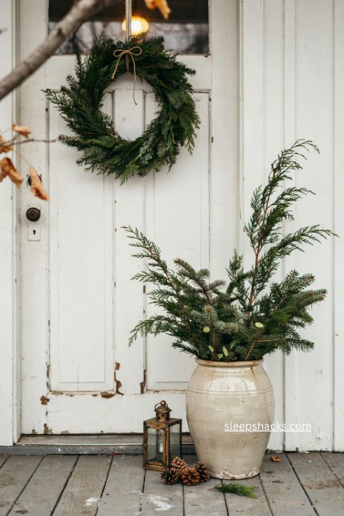 Greenery filled stoneware crock christmas planter for a farmhouse porch
