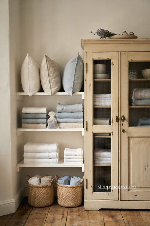 Guest room blanket and linen station with vintage cabinet and open shelving