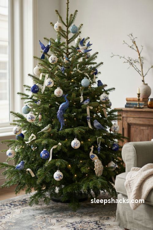 Hand painted chinoiserie bird ornaments and blue floral branches on a Christmas tree
