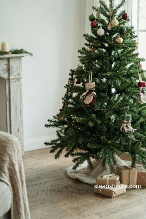 Handmade Christmas sock ornaments on a cozy tree with knitted baubles and warm lights