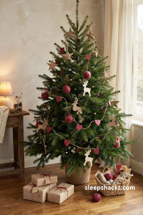 Handmade Christmas tree with kraft paper stars red yarn pom poms cardboard reindeer and wooden heart garland
