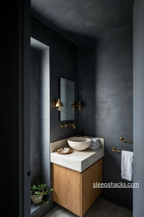 Inky charcoal bathroom paint with matching ceiling white towels and warm lighting