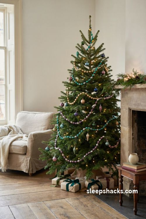 Jewel tone christmas tree with emerald and gold beaded garland and sparkling ornaments