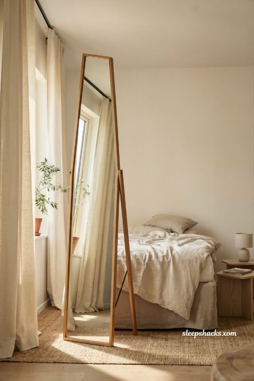 Large leaning floor mirror bedroom ideas with a slim oak frame and cozy neutral decor
