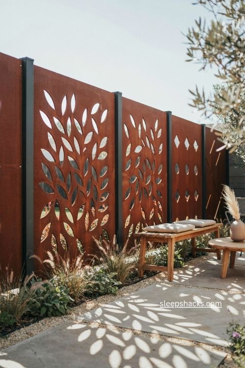 Laser cut corten steel screen with botanical patterns and warm patio sunlight
