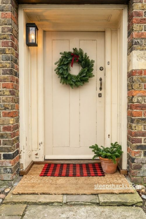 Layered Christmas doormat with a natural coir base and red buffalo check mat at a cozy farmhouse entrance