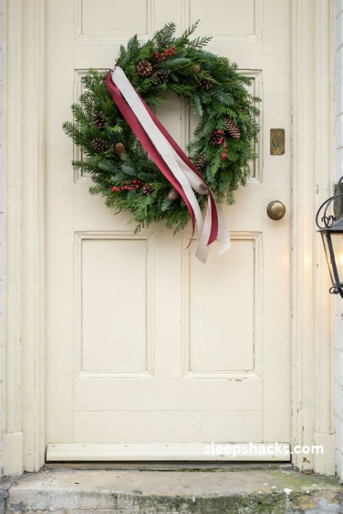 Layered double ribbon Christmas wreath sash with ivory and red satin ribbons on a vintage front door