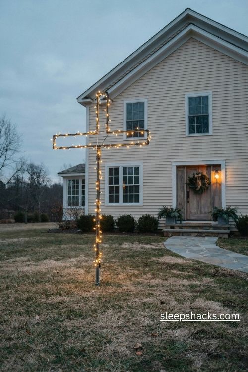 Lighted outdoor cross christmas tree with warm white led lights in a cozy farmhouse front yard