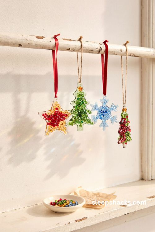 Melted bead Christmas suncatchers in jewel tones glowing like stained glass in a sunny window