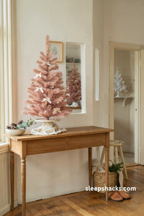 Mini pink Christmas trees throughout the home with pearl ornaments satin bows and warm fairy lights