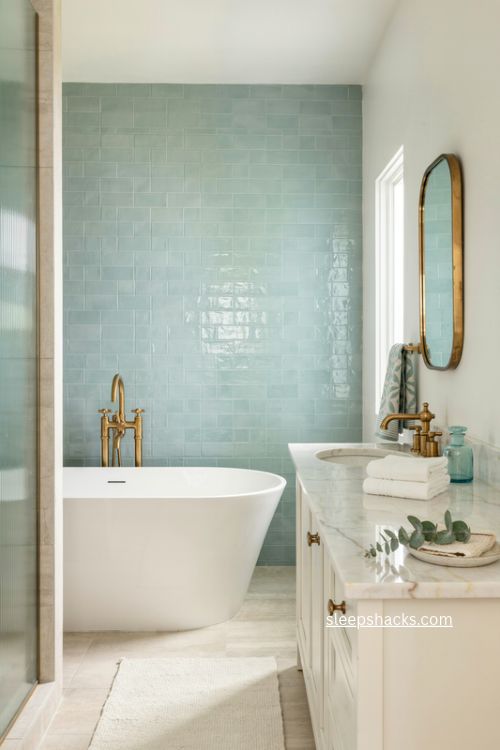 Mint green and white bathroom with marble vanity brass fixtures and fresh accents