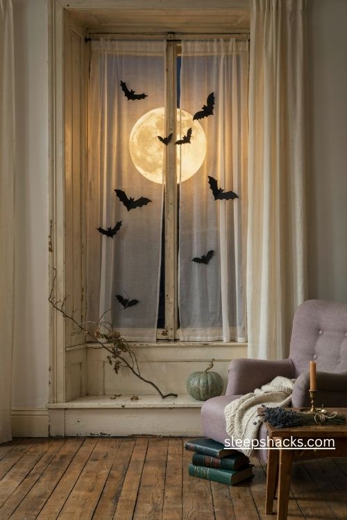 Moon and bat window silhouettes with a glowing paper moon and gothic nightmare before christmas decor