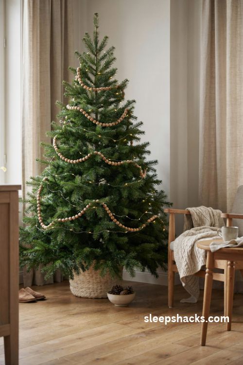 Natural wood bead garland on a simple Christmas tree with warm white lights and Scandinavian decor