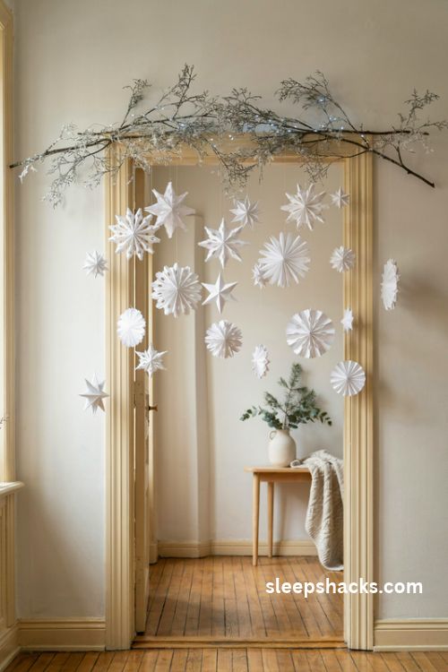 Paper snowflake Christmas arch with frosted branches and delicate hanging winter decorations