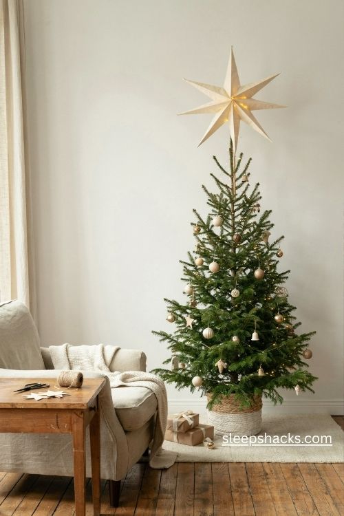 Paper star topper on a slim pencil christmas tree with warm handmade holiday decorations