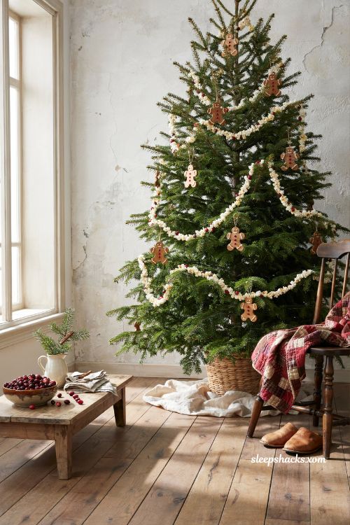 Popcorn and cranberry garland on a rustic gingerbread christmas tree in a cozy living room