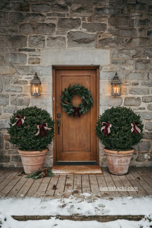 Potted boxwood christmas planters with red velvet bows by the front door