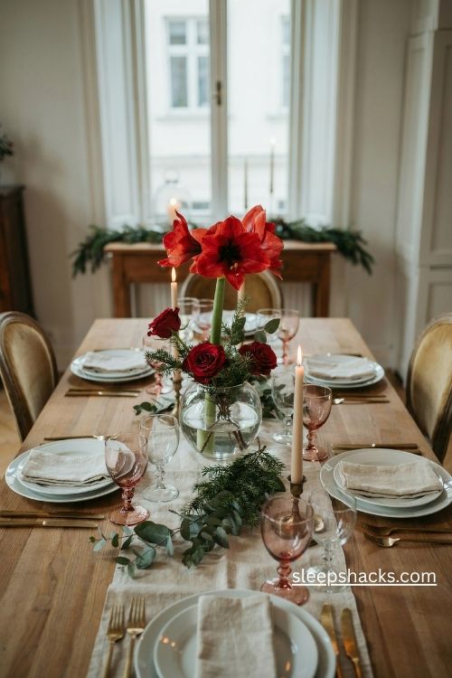 Red amaryllis and rose christmas centerpiece in a low glass bowl with evergreen