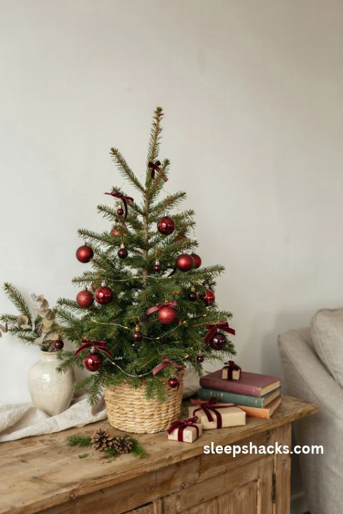 Red and burgundy tabletop christmas tree with mini ornaments and velvet ribbon
