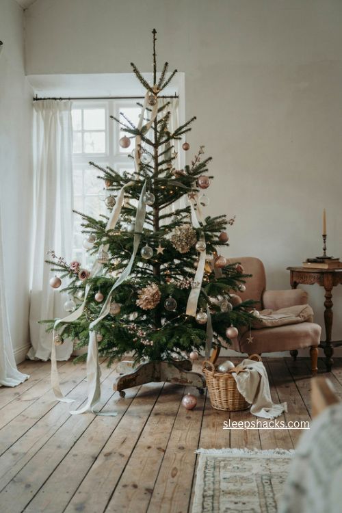 Restrained French country Christmas tree with ribbons flowers and glass ornaments 