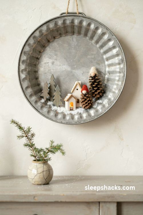 Retro cake pan Christmas diorama with miniature wooden houses, pinecone elves, and sparkling faux snow