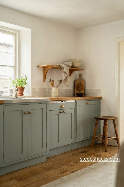 Soft sage green and cream vintage farmhouse kitchen with matte cabinets