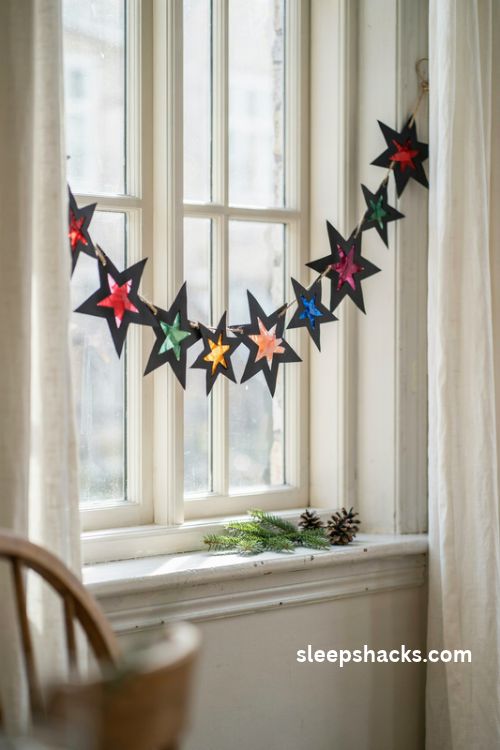 Stained glass Christmas star garland with colorful tissue paper windows across a sunny cottage window