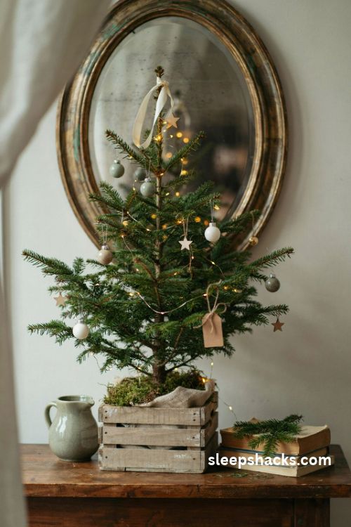 Tabletop Christmas tree in a weathered wooden crate with tiny ornaments burlap moss and warm fairy lights