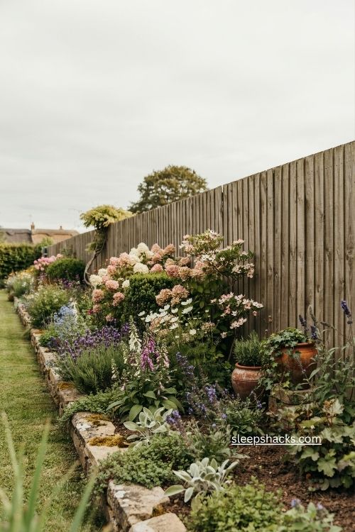 Three layer fence line landscaping with shrubs perennials and groundcover