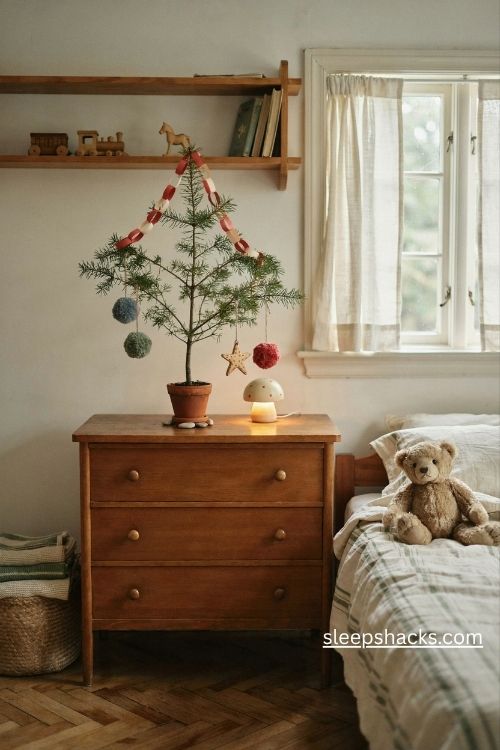 Tiny charlie brown christmas tree with handmade paper chains and pom pom ornaments in a cozy kids bedroom