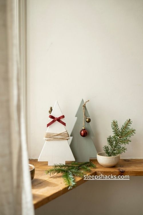 Tiny ornaments and twine accents on painted wooden Christmas trees