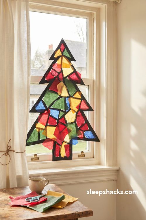Tissue paper Christmas stained glass window panels with colorful mosaic tree designs and glowing sunlight