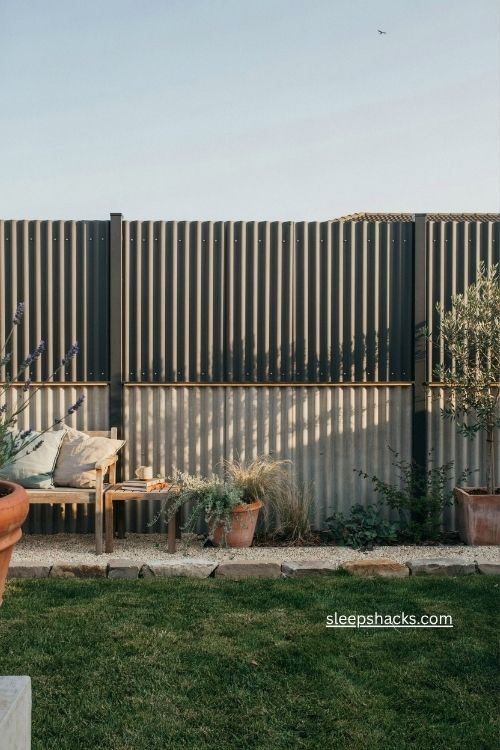 Two tone corrugated metal fence with contrasting trim and modern backyard landscaping