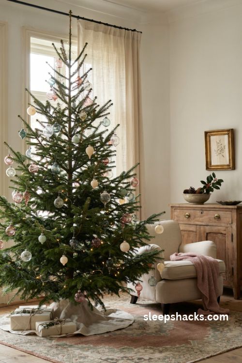 Vintage glass christmas tree with faded pastel heirloom ornaments and warm white lights