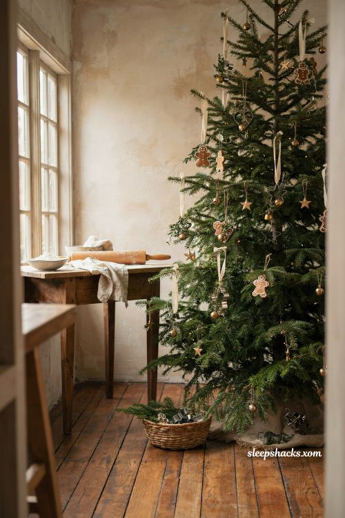 Vintage metal cookie cutter ornaments hanging on a gingerbread christmas tree in a cozy kitchen