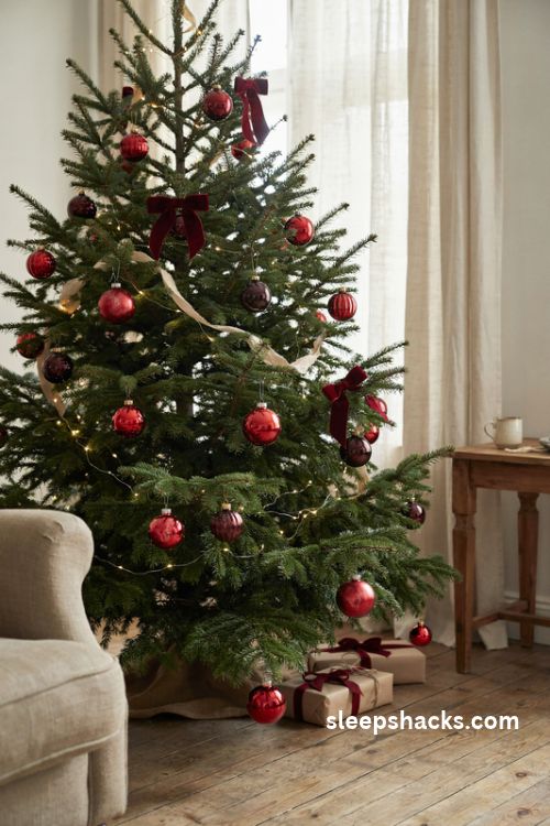 Vintage red glass christmas ornaments with burgundy velvet bows on a traditional tree