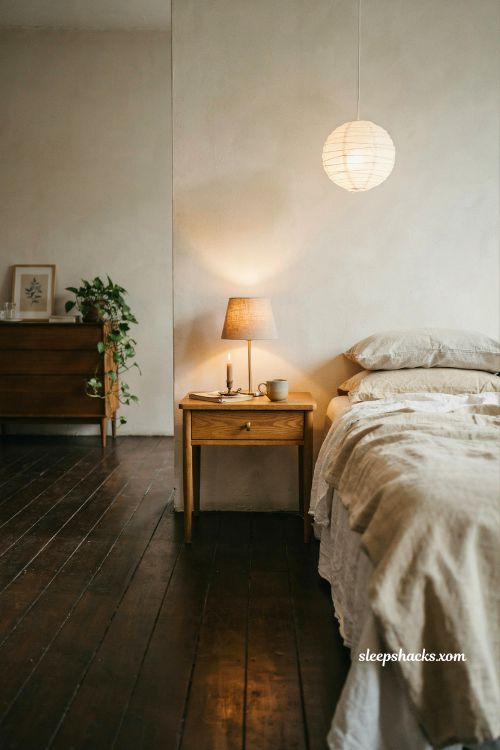 Warm evening lighting with linen lampshades and paper pendant in a cozy cream bedroom