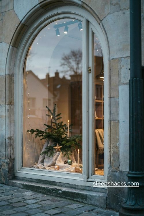 Warm white christmas storefront lighting with glowing string lights candle lamps and evergreen decorations